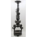 A Qing dynasty Chinese bronze altar candle holder, having dragon entwined stem, supported by two
