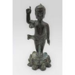 A 19th century Chinese bronze depicts the child Buddha, standing upon a lotus base, one arm raised