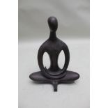 A bronze stylised meditating human figure, 42cm high