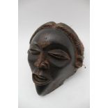 An African carved wood Chokwe mask, considered to be Congo, with fabric cap section, 18cm high