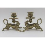 A pair of brass candlesticks in the form of mythical lions, 11cm high