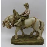 A Royal Dux ceramic figure of a harnessed cart horse being ridden by a boy, on a ground work base,