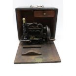 A small Victorian sewing machine, black lacquered cast iron, with gilded decoration, 20cm wide (