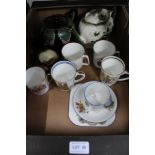 A box containing two collectable teapots, Royal Doulton character jug, commemorative beakers etc.