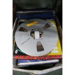 A box containing a large selection of vintage reel to reel tapes and records