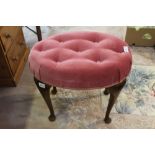 A pink Velour buttoned oval pad top four-legged stool