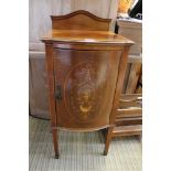 A Sheraton revival bow front bedside pot cupboard, cross banded with arched upright, the