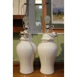 A pair of plain white glazed pottery table lamps in the form of lidded vessels