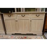 A limed wood effect side unit having three in line drawers of the three plane panelled cupboard