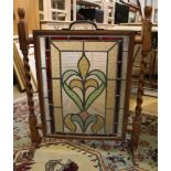 An oak framed multicoloured leaded stained glass panel fashioned as a fire screen