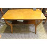 A rectangular topped mid-century design coffee table on four shaped legs united by a magazine