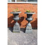 A pair of cast iron campagna form garden urns on plinth base, grey painted. Overall 110cm high