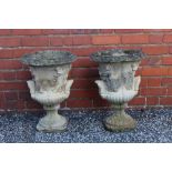 A pair of reconstituted stone garden urns, two handled form cast with classical figures, fluted