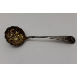 Thomas Wallis A Georgian silver sifting lade, chased handle, the bowl embossed with fruits & gilded,