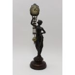 A Junghans mystery clock, a bronzed spelter classical lady, holding aloft the mechanism, raised on a