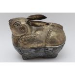 A Far Eastern white metal box in the form of a rabbit, chased and repousse decoration, 11.5cm high
