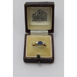 An 18ct gold ring, set central sapphire, flanked by a brilliant cut diamond to either side, gross