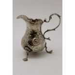 Charles Hougham A George III silver cream jug, 'C' scroll handle, embossed floral decoration, raised