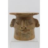 A terracotta pedestal plate, the base in the form of a head, considered to be Pre-Columbian (