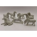 A collection of eight Chinese white glazed ceramic horses, the tallest 9cm high