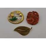 A 14k gold brooch, pierced & chased, with a jade mounted junk at sea, together with a leaf form