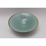 A Chinese porcelain celadon glazed conical bowl, internal relief decoration of a phoenix and a