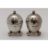 James Dixon & Sons Ltd. A pair of silver ovoid mustard pots, each raised on three ball feet,