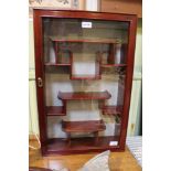 A mahogany coloured oriental design set of hanging display shelves