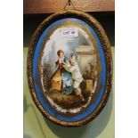 A late 19th century painted porcelain oval plaque depicting courting couple, in a pressed metal