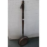 An antique copper headed warming pan with turned wooden handle