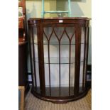 An oak finish bow front china cabinet with fancy bar glazed door and sides