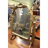 A gilt framed adjustable dressing table top mirror