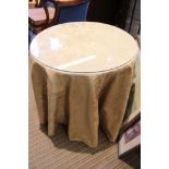 A useful circular topped occasional table with glass protector over quality old gold material