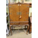 A reproduction walnut coloured cocktail cabinet twin doors opening to reveal mirror backed glass