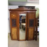 An Edwardian part fitted compactum style wardrobe central mirror door flanked by two carved panel do