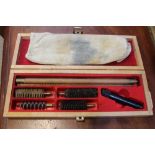 A wooden gun cleaning kit with all accompanying cleaning heads and rag