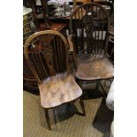 A wheel back country kitchen arm chair together with one other similar single chair