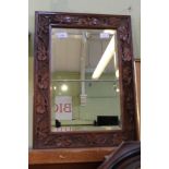 A carved oak framed bevel wall mirror