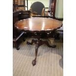 A good quality mahogany finish, pie crust edged coffee table. On short turned column and three outsw