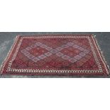 A 20th century Kilim, the field a lattice of lozenges, with red and blue grounds