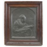 A 19th century embossed copper panel of an old lady reading, 27cm x 22cm