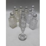 A collection of ten square form spirit decanters, with facet cut stoppers