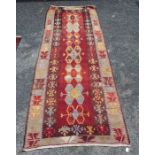 A 20th century Kilim runner, central red ground, with stylised pattern