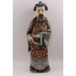 An early 20th century Chinese ceramic Immortal, carrying a Ruyi sceptre