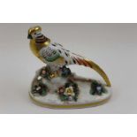 A 20th century porcelain model of an Asiatic pheasant, painted and gilded on a floral encrusted base