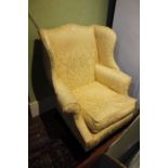 A 20th century gold floral upholstered pattern wing back armchair