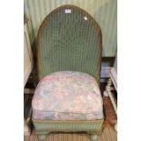 A green Lloyd Loom low bedroom chair
