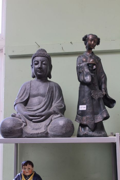 A seated meditive Buddha together with a Geisha figurine