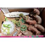 A box containing a selection of model frogs and pigs