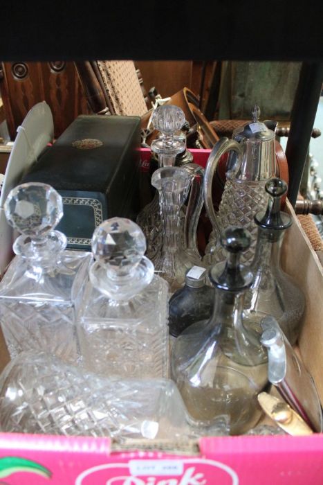 A box containing decanters, claret jug, leather cased spirit flasks